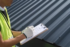 expert inspecting metal roof