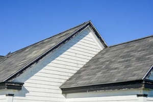 multiple peaked and layered roofs on a white vintage wooden house