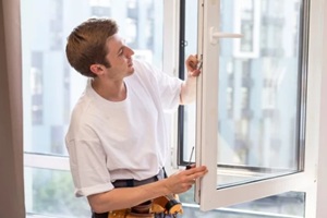 a repairman repairs, adjusts or installs metal-plastic windows in the apartment