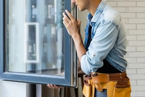 construction worker installing new windows in house