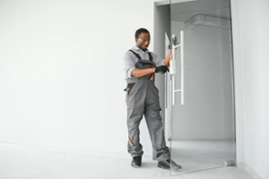 worker installing glass door at office