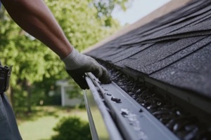 man inspecting roof gutters