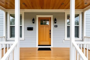 cozy home entryway featuring wooden front door and decorative railing